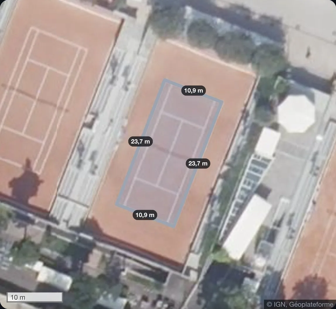 Un court de tennis en terre battue vu du ciel, tracé dans l'application : 23,7 m de long et 10,9 m de large